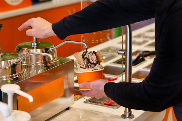 istock Making frozen yogurt with chocolate syrup and toppings at the buffet 1322182872
