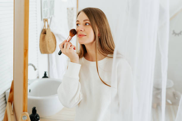 istock woman standing near mirror and doing makeup 1322184813
