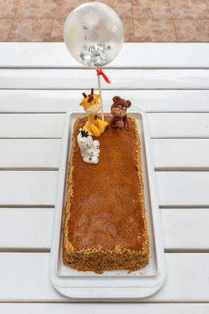 istock Children's birthday cake with giraffe, monkey and zebra 1322185461
