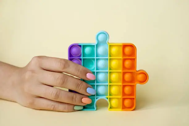 Photo of In the female hand, the popular popit toy. Anti-stress toy