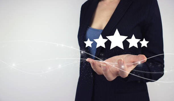 istock Product service evaluation concept. Hand hold digital hologram five stars on grey background. Client giving a Five Star Rating 1322189235