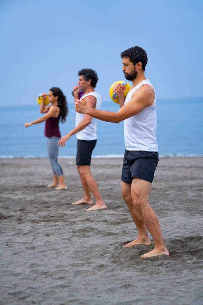istock group of people exercising at the beach with kettle bells 1322189895