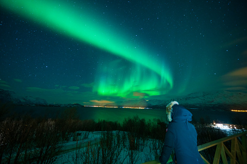 Female traveler looking at Northern lights in Norway