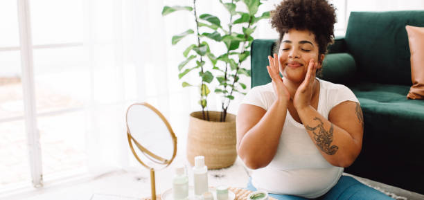 mujer aplicando crema facial en casa - beautiful human skin beauty healthy lifestyle fotografías e imágenes de stock