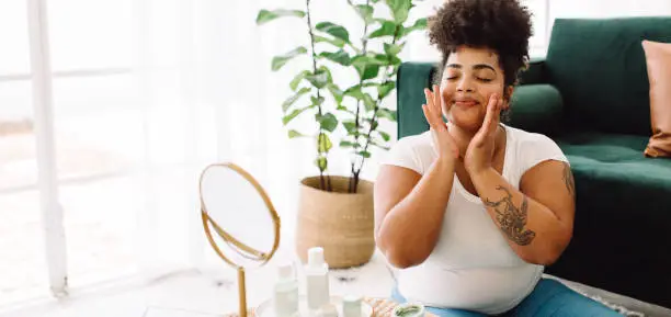 Photo of Woman applying facial cream at home