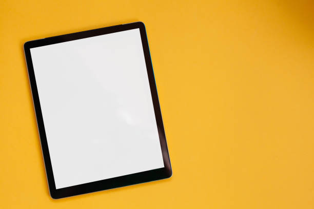 istock Tablet screen mockup isolated on yellow background, top view 1322192290
