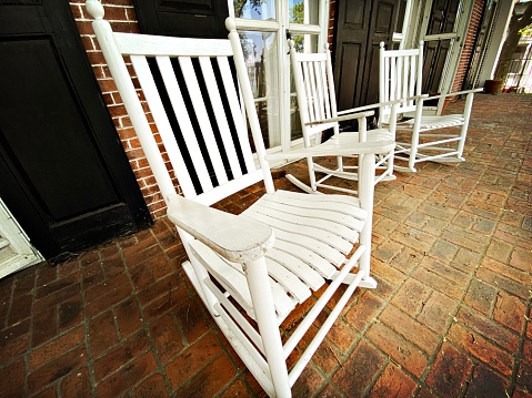 3 White Rocking Chairs on a Porch