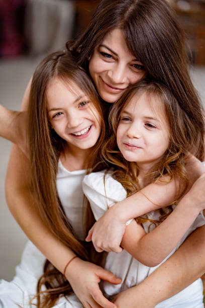 istock mom hugs daughters rides on a swing in the loft. 1322192464