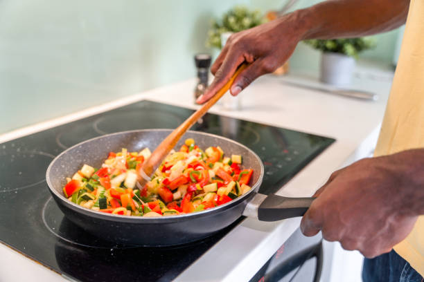 istock Black Male in 30s Mixing Food While Cooking 1322193419