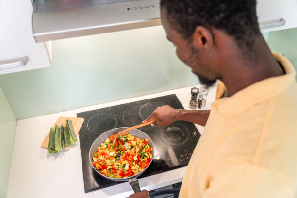 istock Black Male in 30s Mixing Food While Cooking 1322193425