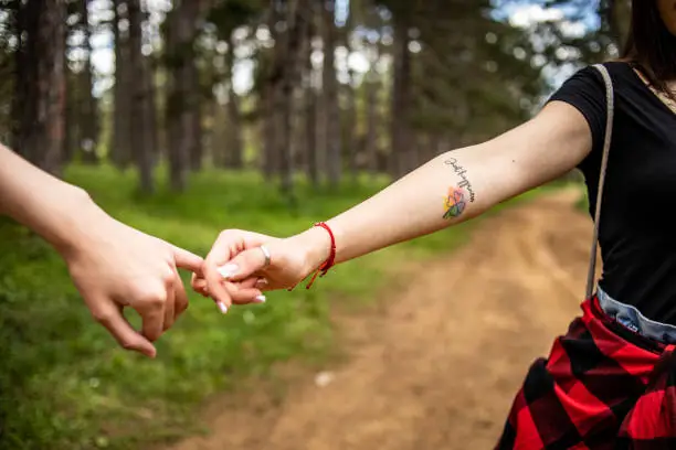 LGBT lesbian couple spending time in nature, using a beautiful day for a walk together and moments of happiness.