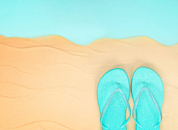 istock flip flops on the sea sand 1322196153