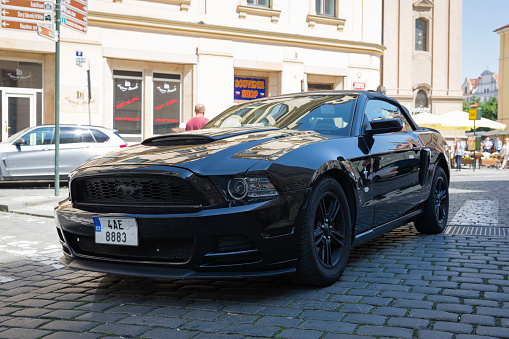 Prague, Czech Republic, may 19th 2017, front/side view of a parked Czech fifth generation 2014 black Ford Mustang cabrio in a street downtown Prague - Prague is considered to be one of the most beautiful cities in Europe and is a popular travel destination for tourists, many of which choose to rent a luxury car while staying there