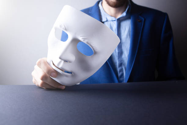 businessman holding white mask in his hand - employee theft imagens e fotografias de stock