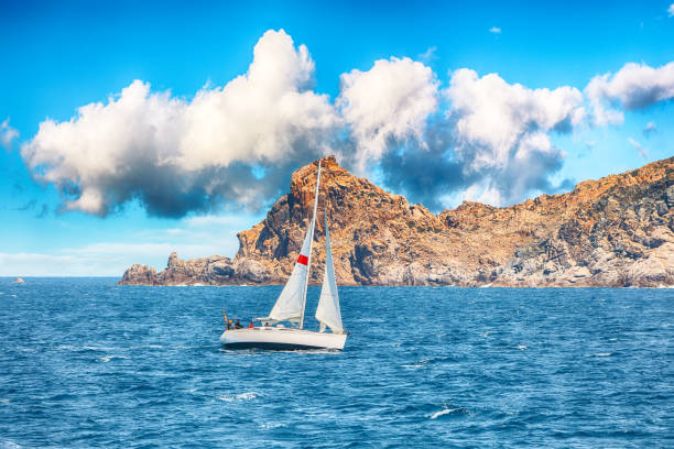 Splendid view of sailboat sailing near the cliffs of  Santa Teresa Gallura. Popular travel destination of Mediterranean sea. Location: Santa Teresa Gallura, Province of Sassari, Sardinia, Italy, Europe
