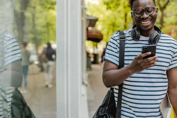istock African-American confident young man is using mobile phone on the street 1322199145