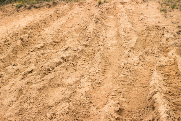 klettern sandige straße nach regen mit spuren von rutschenden autos. schlamm und sand offroad hintergrund. anspruchsvolle strecke für autorennen. - skidding car tire rain stock-fotos und bilder