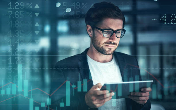 istock Digitally enhanced shot of a handsome businessman using a tablet superimposed over a graph showing the ups and downs of the stock market 1322205511