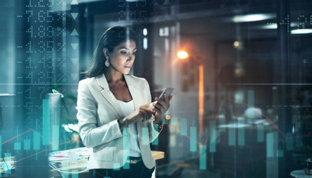 Digitally enhanced shot of an attractive businesswoman using a cellphone superimposed over a graph showing the ups and downs of the stock market Better accessibility, more productivity stock certificate photos stock pictures, royalty-free photos & images