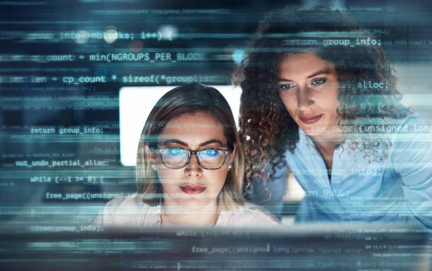 Digitally enhanced shot of two attractive businesswomen working in the office superimposed over multiple lines of computer code Two people will get it done twice as fast database stock pictures, royalty-free photos & images