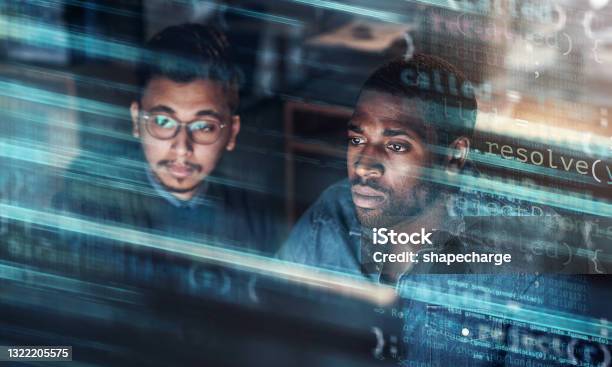 Digitally Enhanced Shot Of Two Handsome Businessmen Working In The Office Superimposed Over Multiple Lines Of Computer Code Stock Photo - Download Image Now