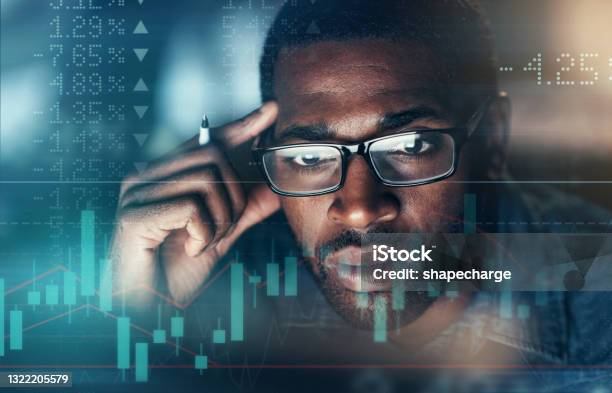Digitally Enhanced Shot Of An Unrecognizable Businessman Working In The Office Superimposed Over A Graph Showing The Ups And Downs Of The Stock Market Stock Photo - Download Image Now
