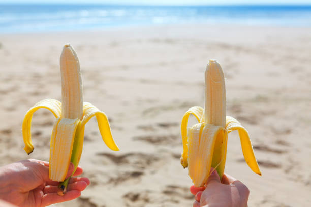 istock Holding in hands bananas on the beach 1322209385