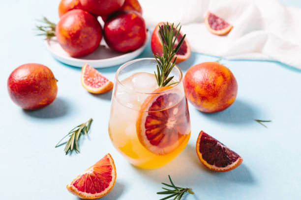 istock Delicious Blood Orange Cocktail on light blue background. Summer cocktails, refreshing drinks, low alcohol mocktail concept. 1322210794