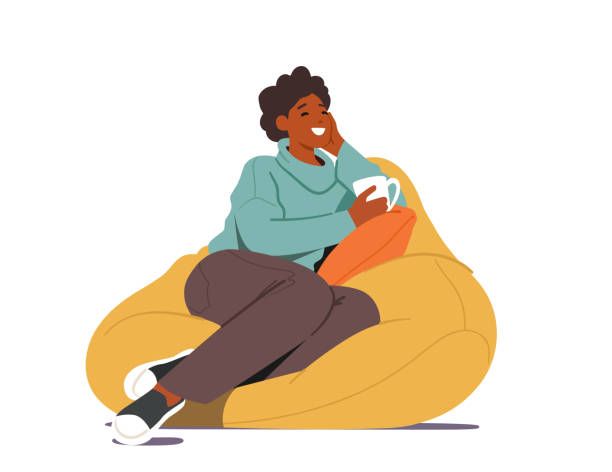 молодая женщина сидит на бобовой сумке с чашкой чая или кофе в руке дома. женский персонаж посещение друга, имея досуг - drinking tea cup drink stock illustrations