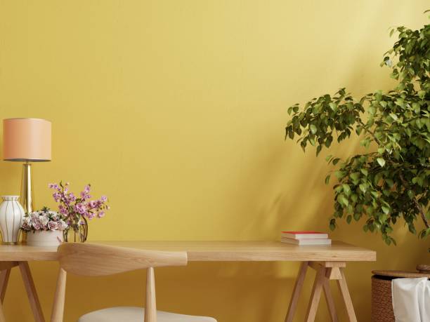 Office desk interior with mockup yellow wall.