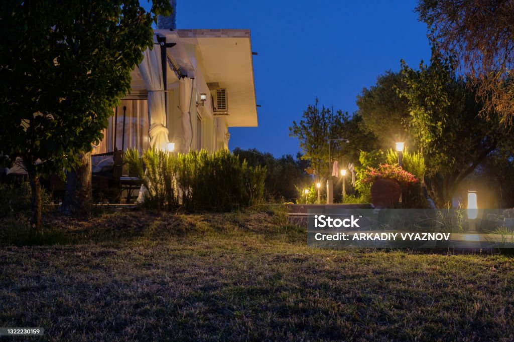 Yard and bungalow lit by lanterns. Night on the sea coast. Yard and bungalow lit by lanterns. Night on the sea coast. Halkidiki, Greece. Lighting Equipment Stock Photo