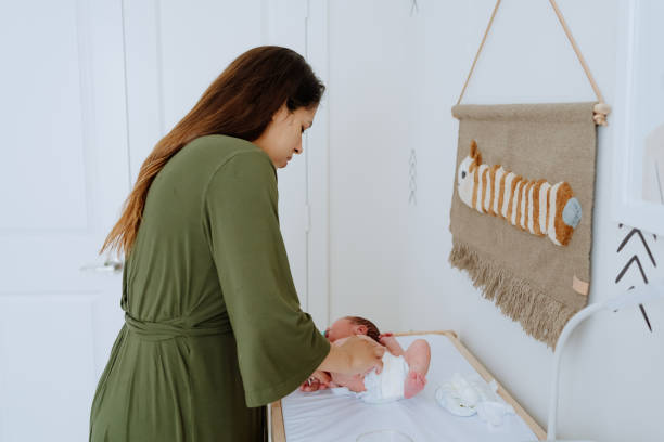 istock Mother changing her baby diapers 1322239309