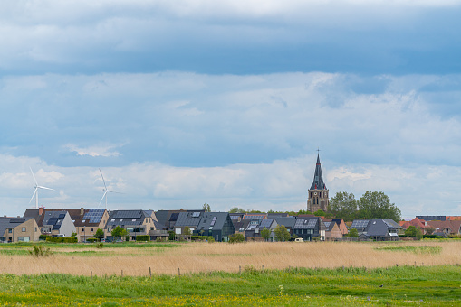 On a dark day with lots of clouds there is a beautiful church next the field