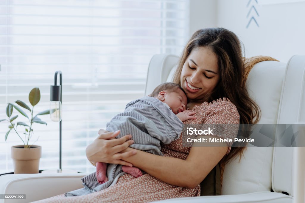 Mother holding her baby boy in the nursery room Newborn Stock Photo