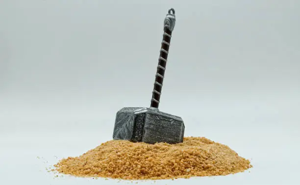 Hammer of Thor, Mjolnir, on the ground isolated on white background. The mythical Thors hammer. Mjolnir a legendary Viking weapon. Empty space for text
