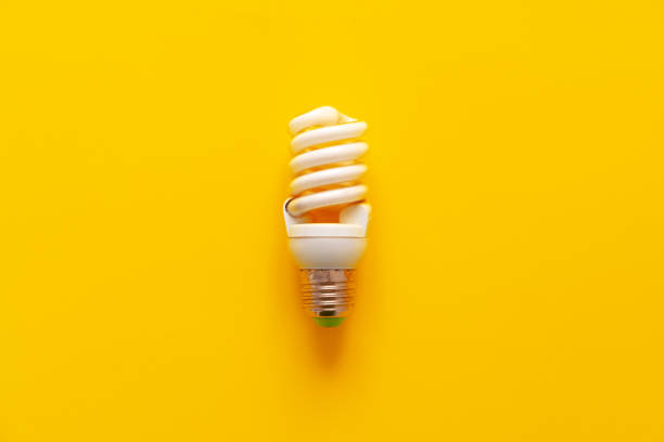 istock Light bulb on yellow paper background top view 1322248045