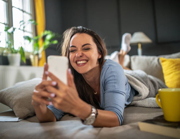 istock Smiling young  woman using mobile phone app playing game, shopping online, ordering delivery 1322248696