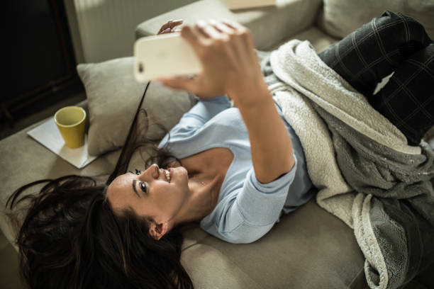 istock Smiling young  woman using mobile phone app playing game, shopping online, ordering delivery 1322249190