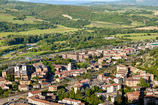 The green Umbrian landscape surrounds the modern district of the medieval town of Orvieto in central Italy, famous for its artistic riches, but also for the production of excellent wines and extra virgin olive oil. In the middle of the image the line of the high-speed railroad track. With a population of just 20,000 people, Orvieto is considered one of the most beautiful cities of art in Italy, founded since the Etruscan and Roman times on the flat top of a large butte of volcanic tuff. This same material was used for the construction of almost all the medieval houses and churches of Orvieto, as well as its famous Gothic-style Cathedral. Image in high definition format.