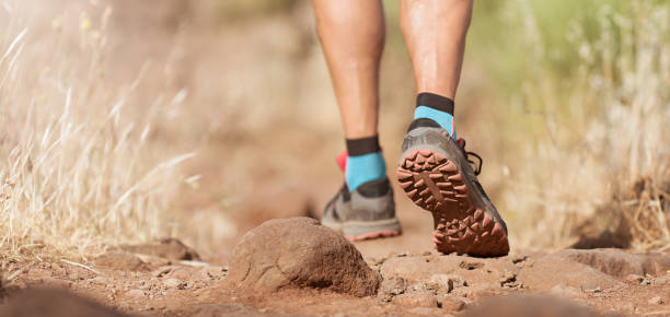 istock Athlete trail running in the mountains on rocky terrain 1322254556