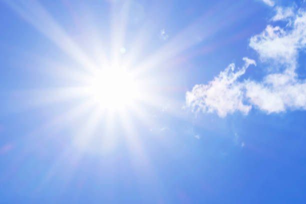 Bright sun with beautiful beams in the sky with light clouds