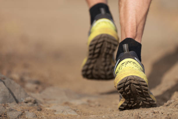 istock Athlete trail running in the mountains on rocky terrain 1322255528