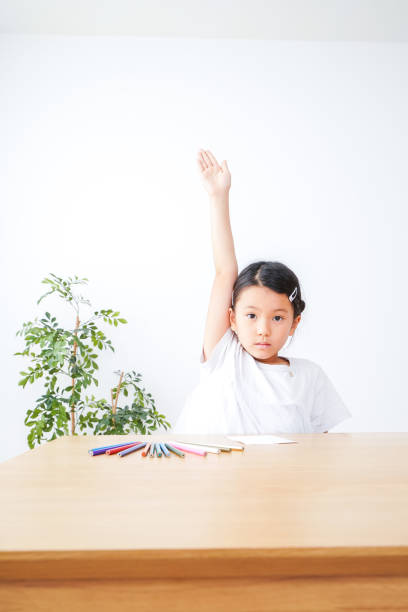 An elementary school girl raises her hand to make a presentation