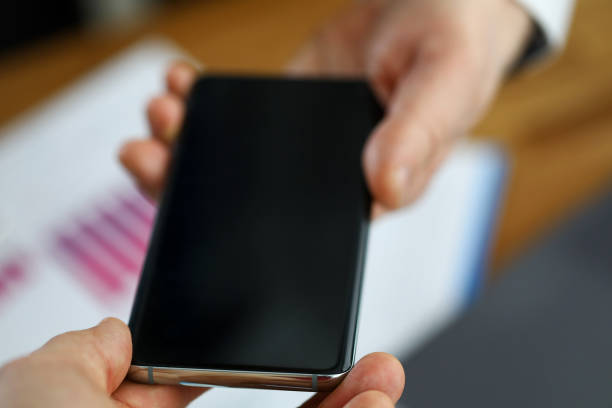 istock Close-up at office men pass each other smartphone 1322255741