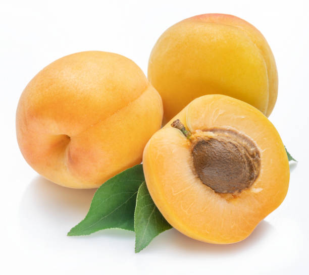 istock Ripe apricots with leaves isolated on white background. 1322255809