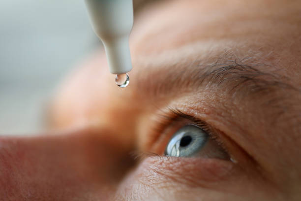 男性は点眼薬をインストールレンズ、保湿をドロップ - out to dry ストックフォトと画像