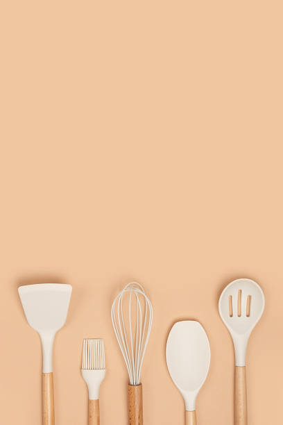 istock Cooking utensil set. Silicone kitchen tools with wooden handle on beige background with copy space. Top view Flat lay 1322257818
