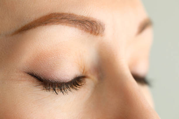 ojos cerrados de hermosa mujer pelirroja bajo el sol de la mañana - parpadear fotografías e imágenes de stock