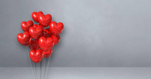 istock Red heart shape balloons bunch on a grey wall background. Horizontal banner. 1322259219