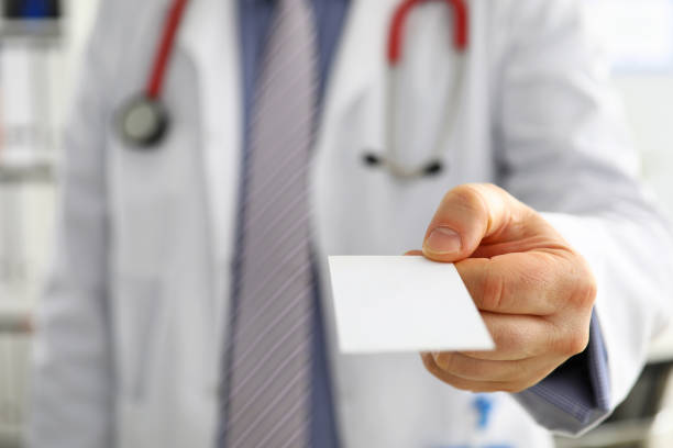 istock Male physician hand holding and giving white blank calling card 1322259863